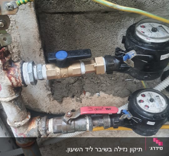 שני מדי מים עם ברזים וצינורות מחוברים לקיר